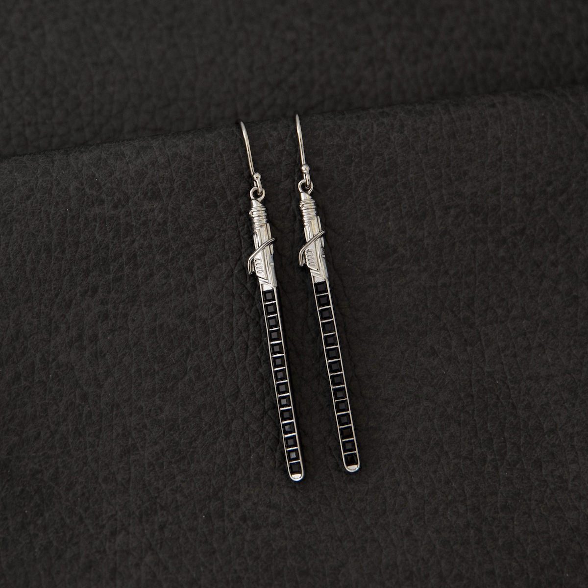 Front view of the pair of Star Wars Darksaber sterling silver earrings on a white background.