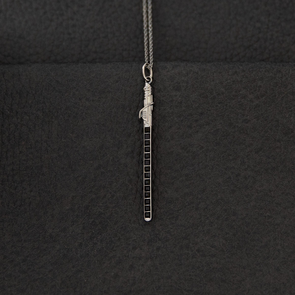 The Darksaber necklace displayed in its official Star Wars | RockLove collector's jewelry box.